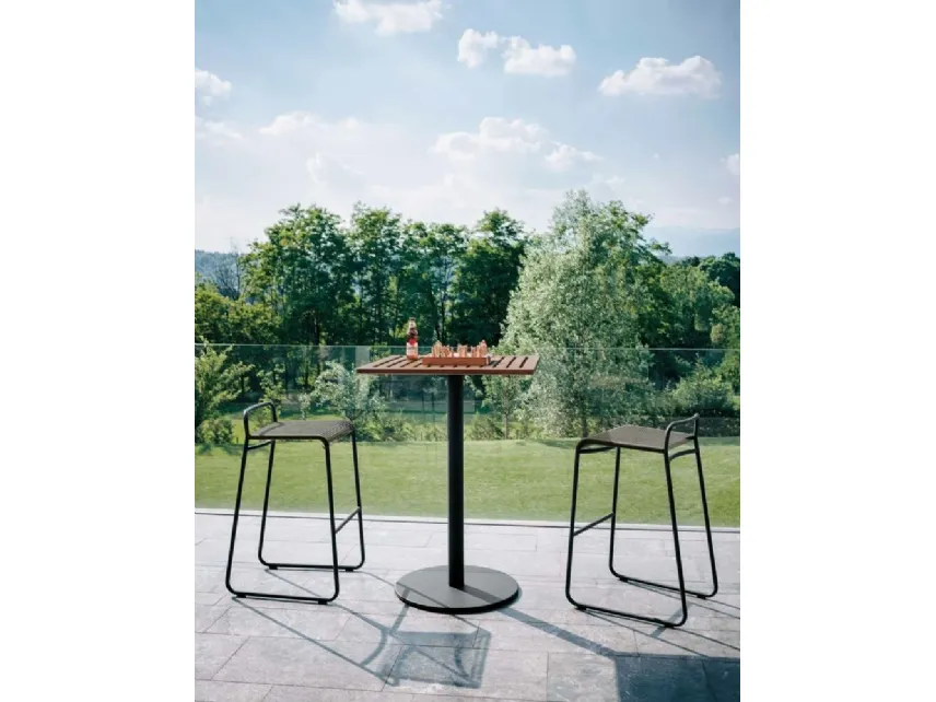 Tavolino da bar per esterno con struttura formata da una gamba centrale in acciaio verniciato a polvere che sostiene il piano dogato in teak naturale Stem di Roda